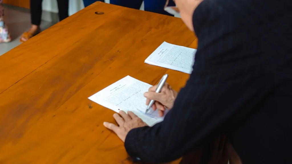 Profesional firmando documentación en un entorno administrativo