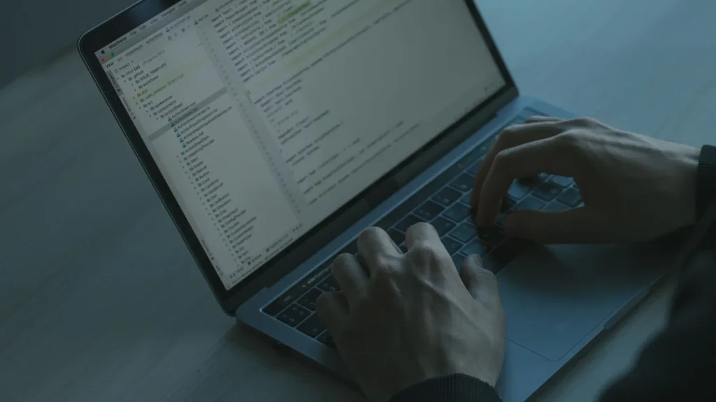 Trabajo con un ordenador y código como referencia a la formación práctica en ciberseguridad para pymes